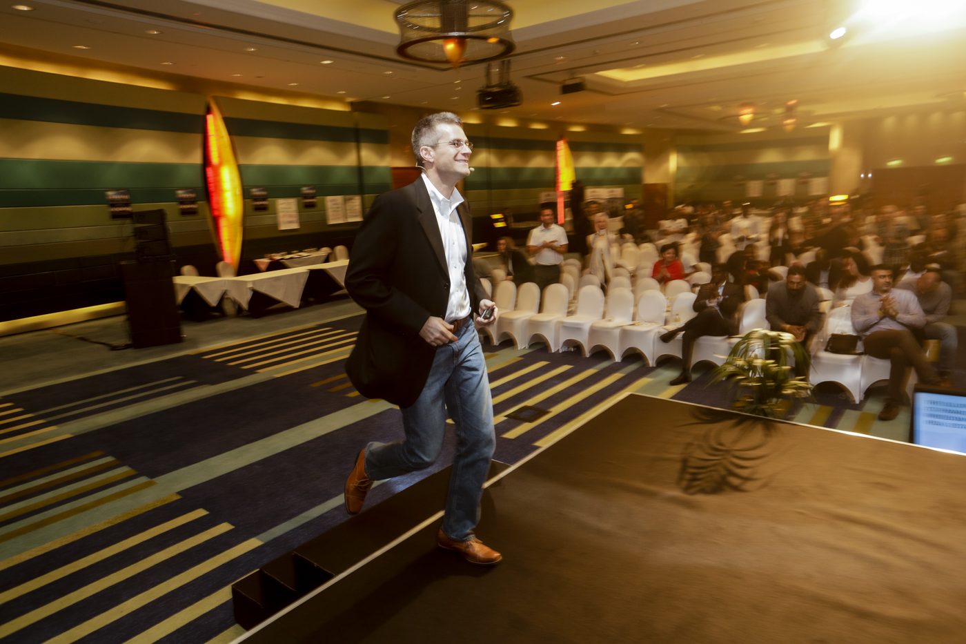 Michael Blank walking on stage in front of a Deal Makers audience